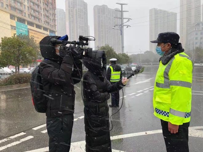孝感市融媒體中心楊亞玲（風(fēng)雪中，采訪疫情期間重返一線的退休警察）_副本.jpg.jpg